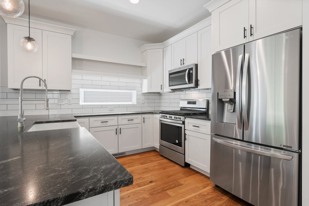 A sleek, modern kitchen featuring white cabinets and stainless steel appliances, ideal for a contemporary home.